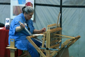 Weaving during Sheep to Shawl a woman weaving on a loom